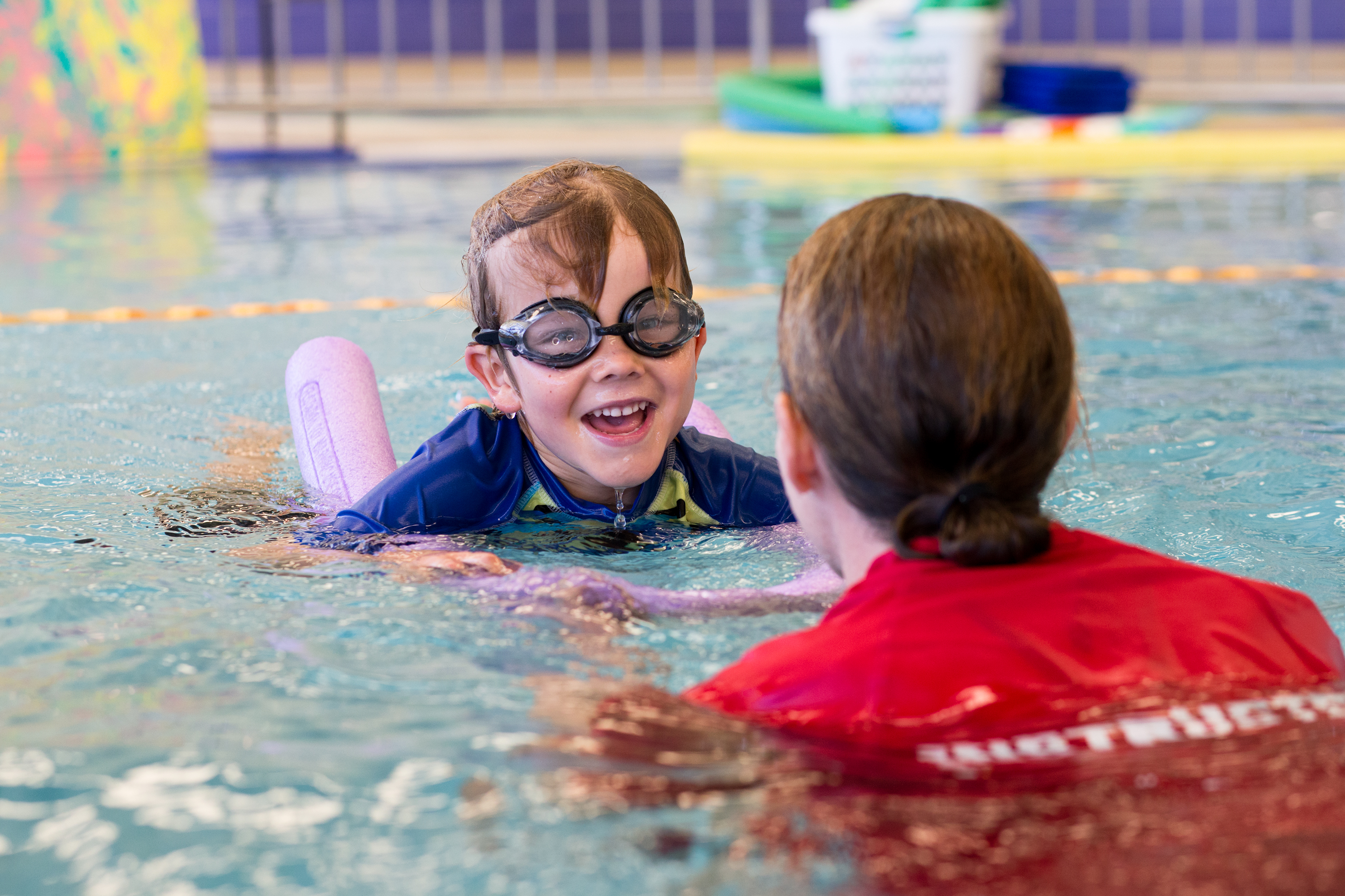 Child swimming with HA swim instructor