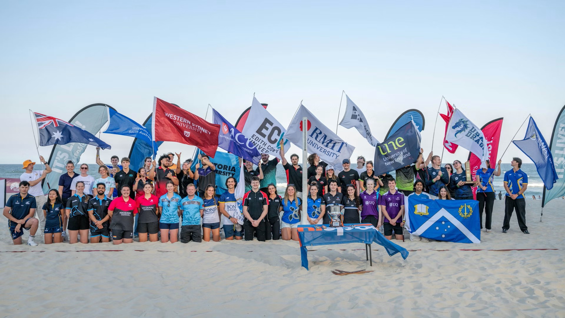 University athletes fly flags at the beach