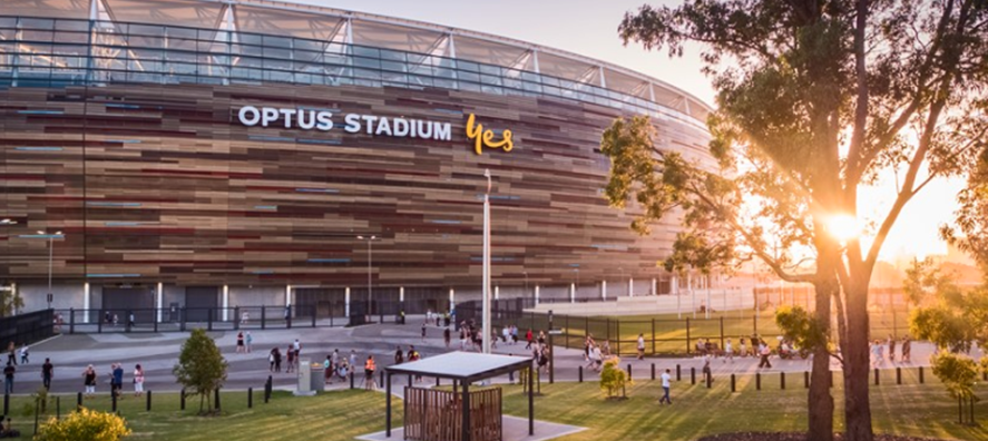 A photo showing a small grassed area and the outside of Optus Stadium in Burswood, Perth