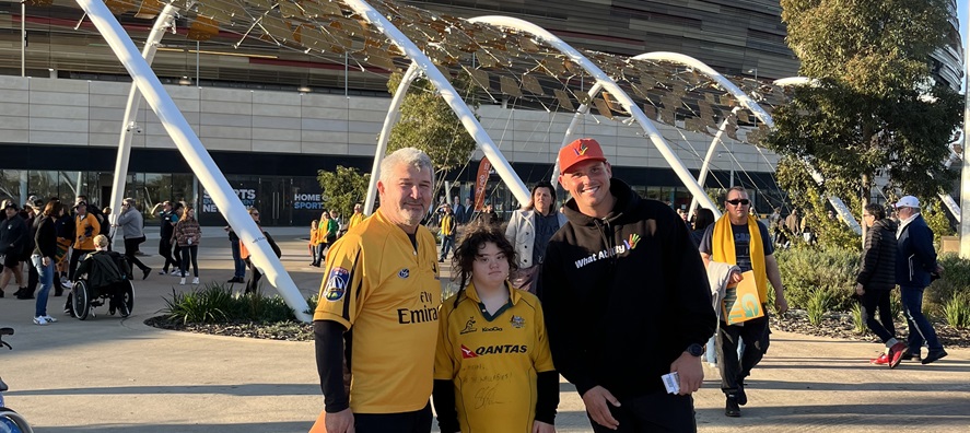 A photo of three people posing for a photo outside of Optus Stadium