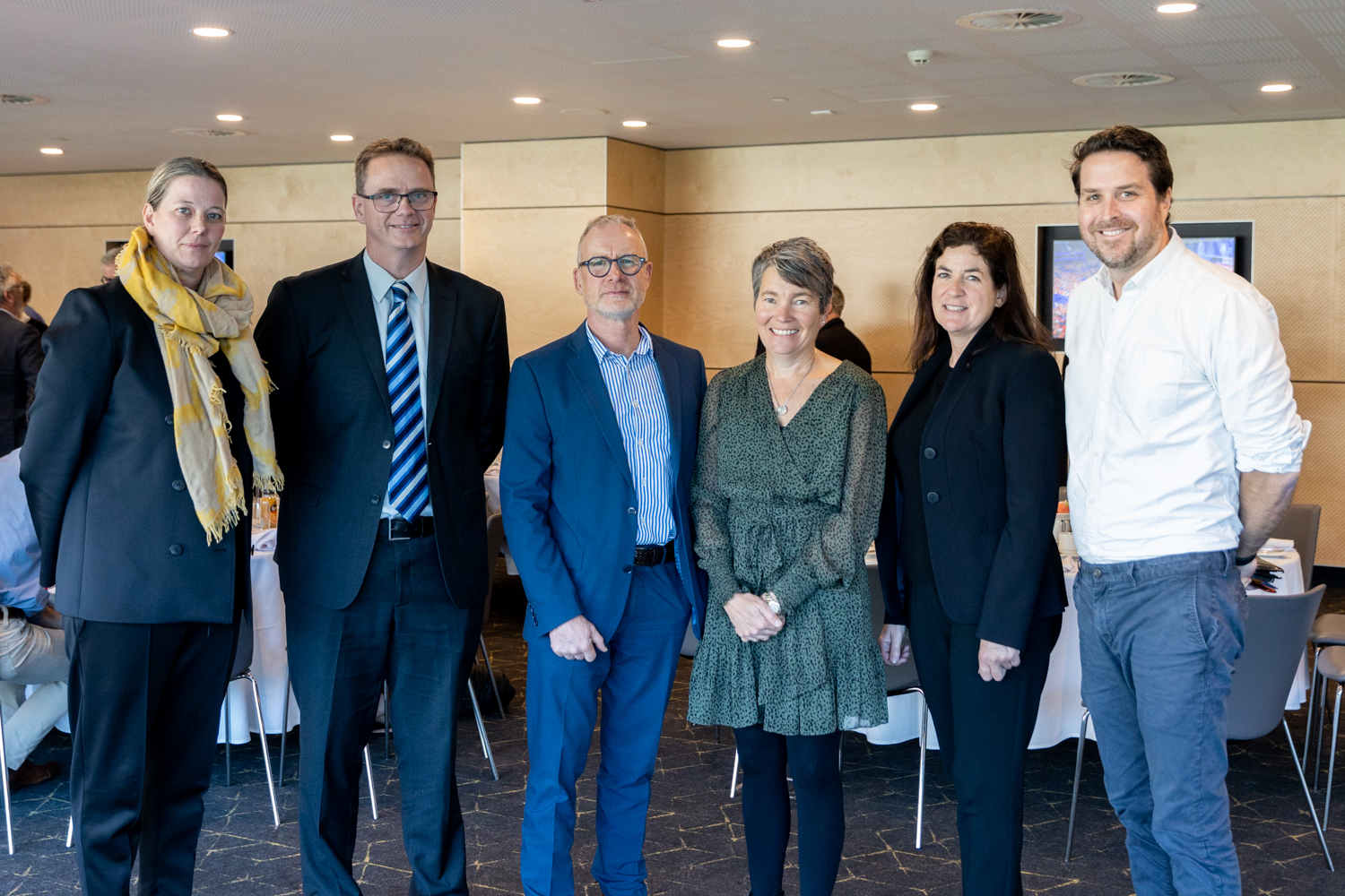 Group photo of six people standing together at the Partners Stakeholders breakfast