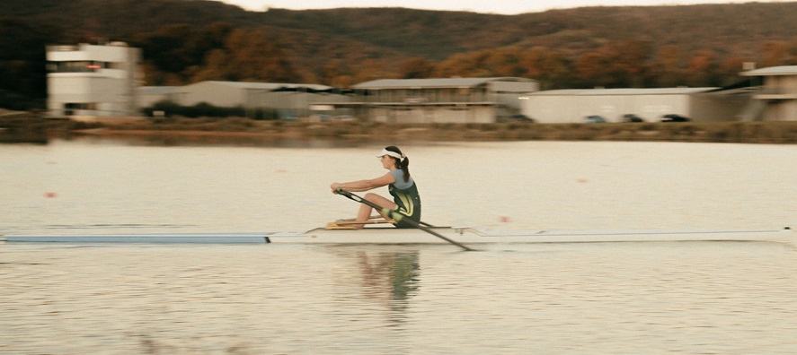 Side on photo of a solo rower on the water at Champion Lakes Regatta Centre