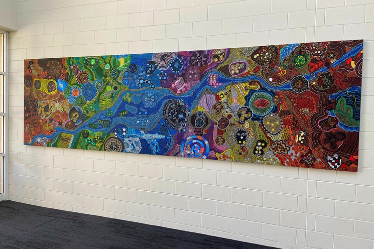 A photo of Aboriginal artwork being hung inside of HBF Stadium