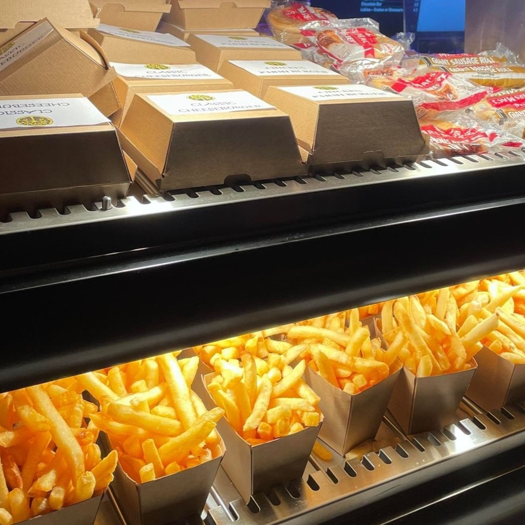 A close up photo of a catering kiosk with two shelves of food on display